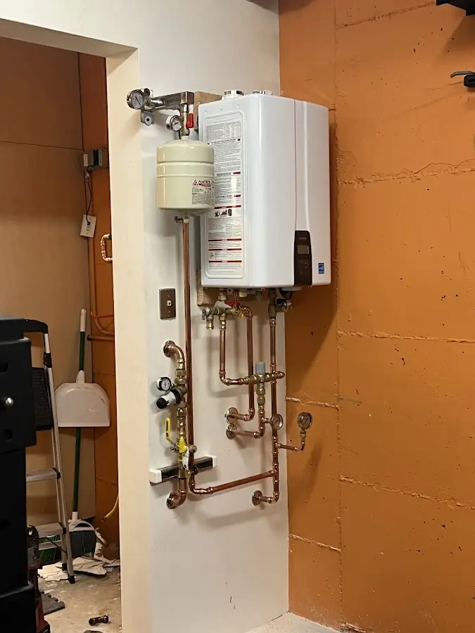 Plumbing technician inspecting water heater connections in Spring